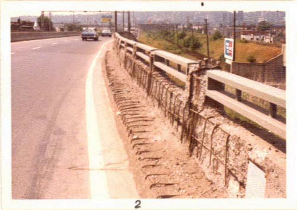 Very extensive concrete disintegration with exposed and rusted reinforcing steel along a highway barrier in section 2 on the Montreal land approach to the main bridge, the main bridge being located in sections 4, 5 and 7 of the corridor Annual inspection report for 1973